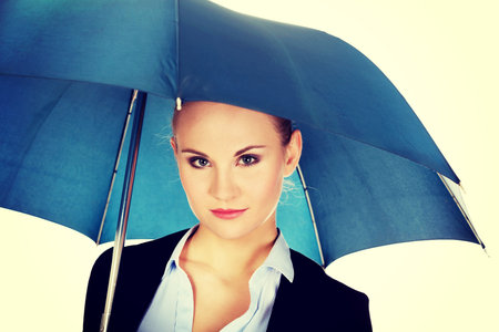 Blonde business woman holding an umbrella.の写真素材