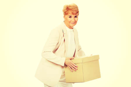 Smile elderly business woman holding cardboard box.の写真素材