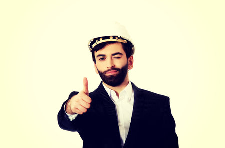 Smiling businessman with hard hat showing ok sign.