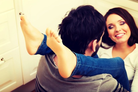 Young woman having her legs around men's neck.の写真素材