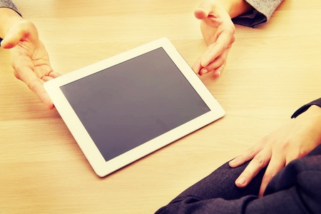 Business meeting-man showing something on tablet.の写真素材