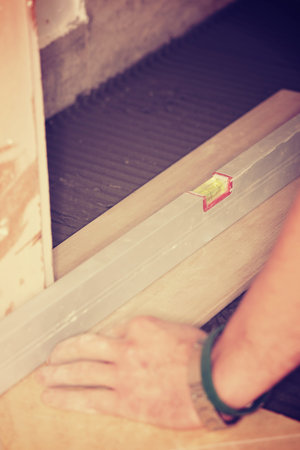 Tiler installs ceramic tiles at home.