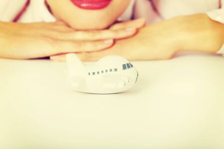 Closeup photo of business woman lying on the desk with toy plane.の写真素材