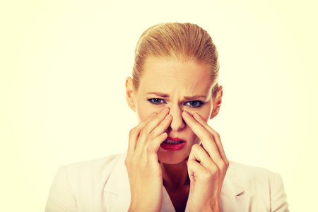 Young business woman with sinus pressure pain.