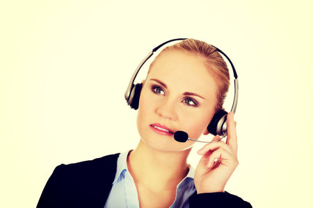Young woman helpline operator is trying to hear something headphones.