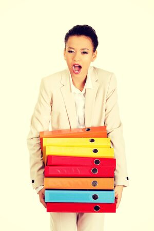 Shocked businesswoman holding heavy bidners.の写真素材