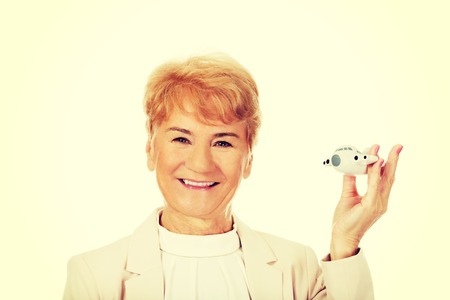 Smile elderly elegant woman holding a toy plane.の写真素材