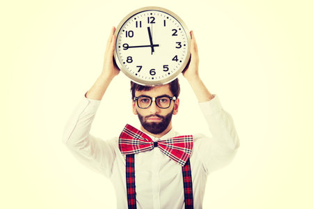 Funny man wearing suspenders holding big clock.の写真素材