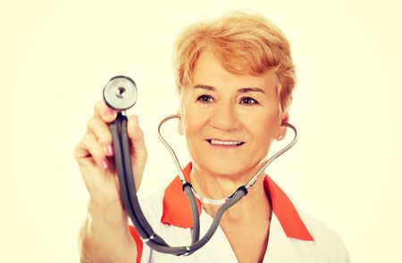 Smile elderly female doctor holding stethoscope.の写真素材