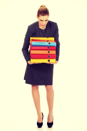 Young business woman carries heavy binders.の写真素材
