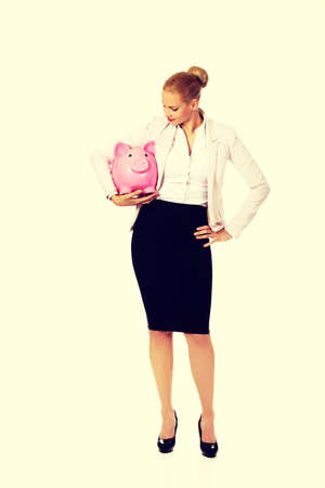 Young business woman holding piggybank.の写真素材