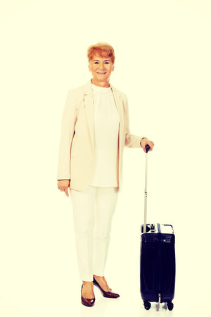 Smile senior woman with suitcase.の写真素材