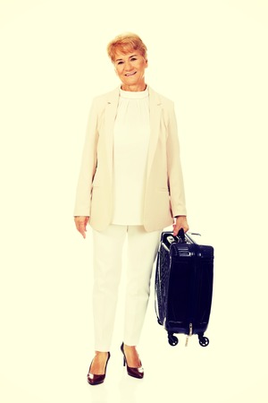 Smile senior woman with suitcase.の写真素材