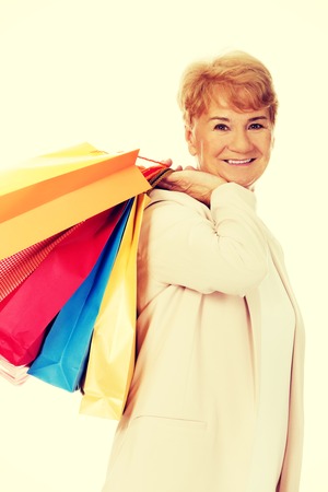 Happy elderly business woman holding shopping bags.の写真素材