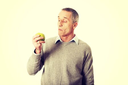 Healthy mature man eating an apple.の写真素材
