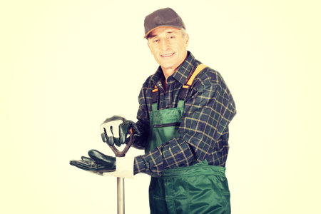 Smiling experienced gardener with a spade