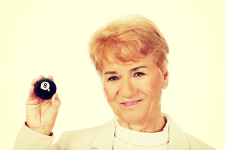 Happy elderly business woman holding eight billard-ball.
