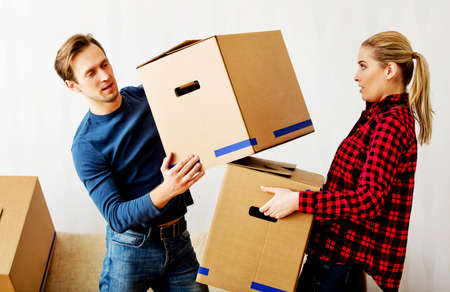 Young couple with boxes - packing or unpacking.の写真素材