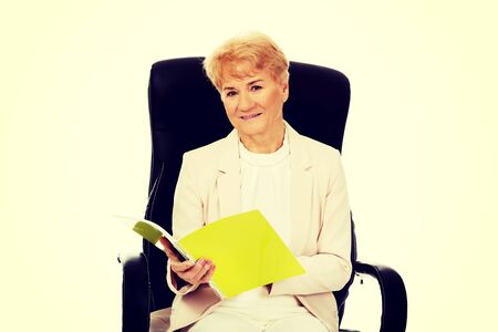 Smile elderly business woman reading a notes.の写真素材