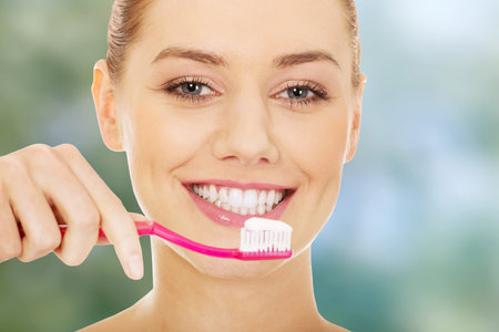 Young woman holding a toothbrush.