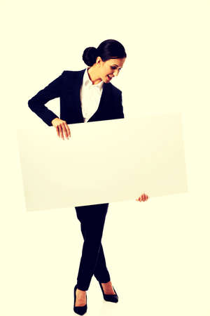 Happy businesswoman holding empty banner.の写真素材