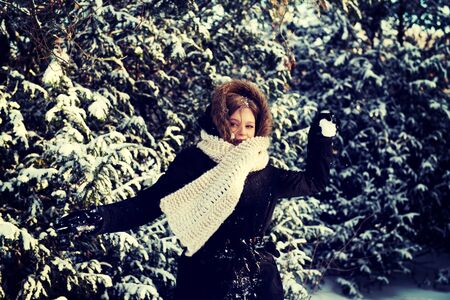 Teenage woman playing snowball fightの写真素材