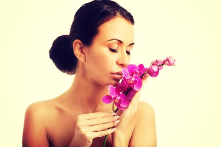 Woman with purple orchid branch and closed eyesの写真素材