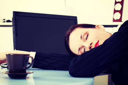 Business woman is sleeping on desk/table in office.の写真素材