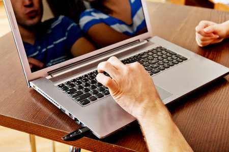 Young man sitting at the table and using laptop.の写真素材