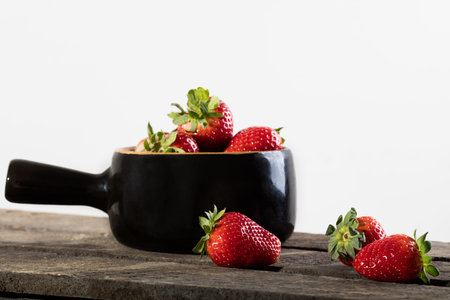 Juicy strawberry in clay vessel.