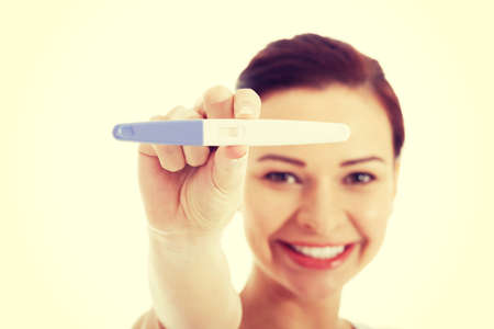 Happy smiling woman with pregnancy test.の写真素材