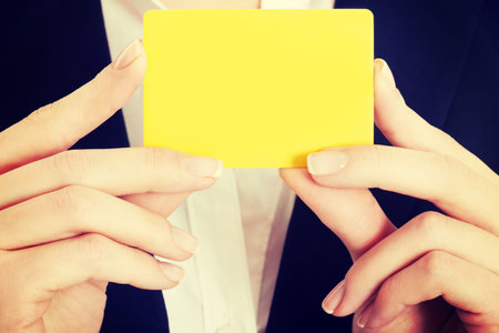 Empty yellow card in business woman's hands.