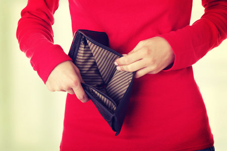 Young woman shows her empty wallet. Bankruptcy