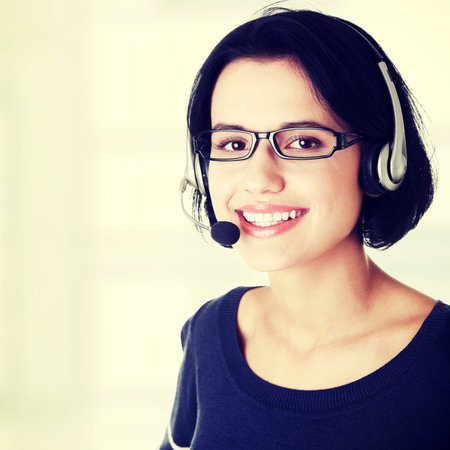 Closeup of attractive customer support representative smiling with headset
