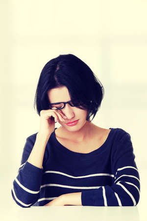 Young sad woman, have big problem or depression, over white backgroundの写真素材