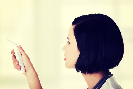 Female doctor or nurse checking temperature of her patient