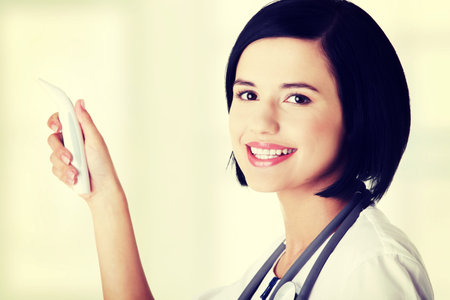 Female doctor or nurse checking temperature of her patient