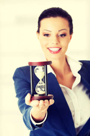 Young business woman with hourglass - time conceptの写真素材