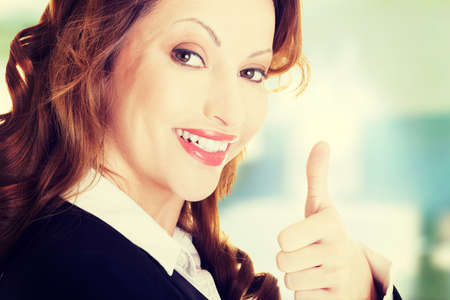 Happy smiling business woman with thumbs up, ok gestureの写真素材
