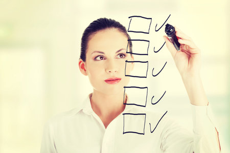 Young businesswoman writing something on abstract screen