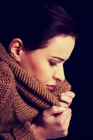 Young woman is having a depression. Over black background.の写真素材