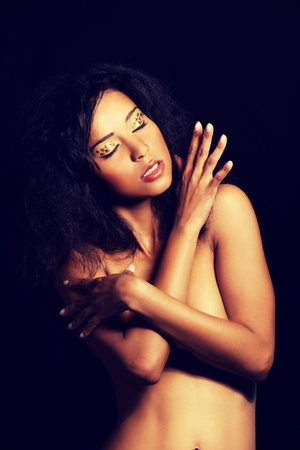 Beautiful mulatto woman with tiger make up. Over black background.の写真素材