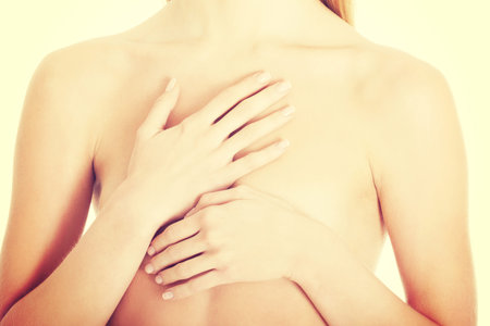 Beautiful caucasian naked woman covering her chest. Isolated on white.の写真素材