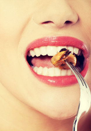 Smiling caucasian woman eating sea fruit with fork. Isolated on white.