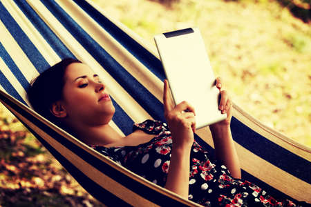 Woman Relaxing In Hammock With  Tablet computerの写真素材