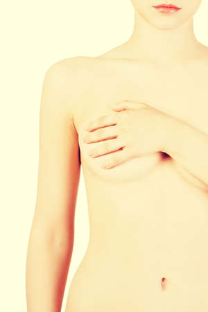 Beautiful woman covering her breasts. Closeup. Isolated on white.の写真素材