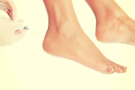 Woman getting an foot injection, isolatedの写真素材
