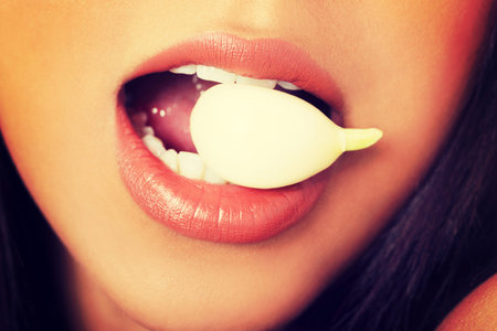 Young beautiful woman eating garlic. Healthy eating concept. Natural antibiotic that fight infection