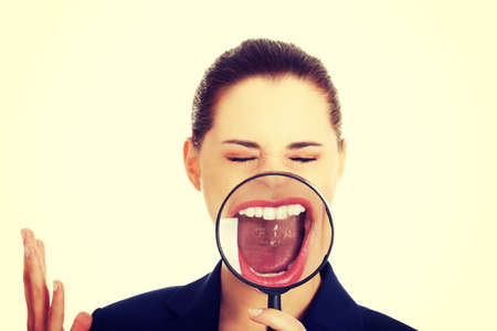 Young smiling business woman looking into a magnifying glass.の写真素材