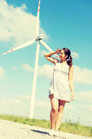 Happy teen girl next to wind turbine.Eco energy concept.の写真素材